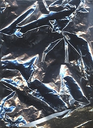 holographic foil paper close-up with rainbow lights. modern trendy background. contrasty crumpled foil package bag. clean packing aluminium, holographic image, silver plastic bag, iridescent color