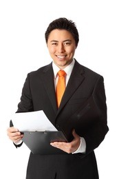 young attractive businessman wearing a suit and tie, holding a folder. white background.