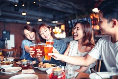 happy young group dining and drinking beer at restaurant