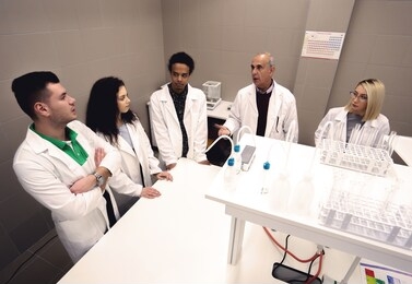 multicurtural laboratory  scientist students working at lab with test tubes
