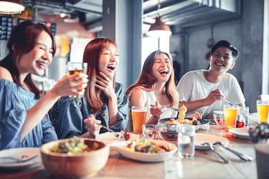 happy young group dining and drinking beer at restaurant