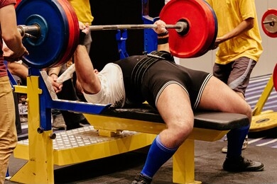 man athlete bench press exercise in powerlifting competition
