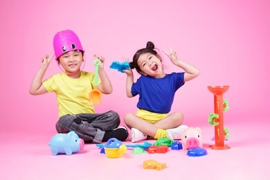 happy asian cute little kid boy and girl playing on pink background