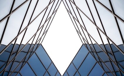 distorted reflection in the mirrored windows of a modern building abstract geometric color blue architectural background pattern
