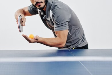 cropped image of bearded ping pong player serving ball in the beginning of game