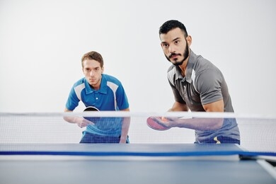 serious young multi-ethnic team of players playing table tennis