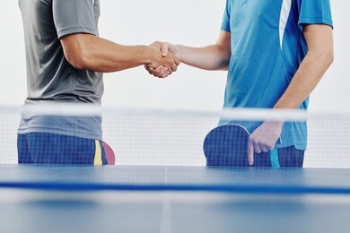 cropped image of table tennis players shaking hands before playing game