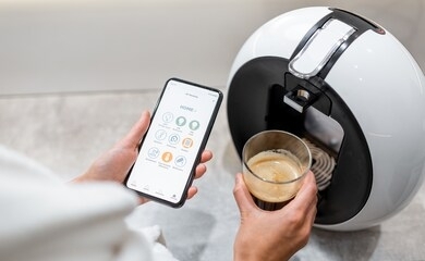 cotrolling coffe machine with a smart phone, close-up on phone with launched smart home application