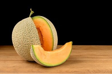 melon fruit sliced on wooden table with black background