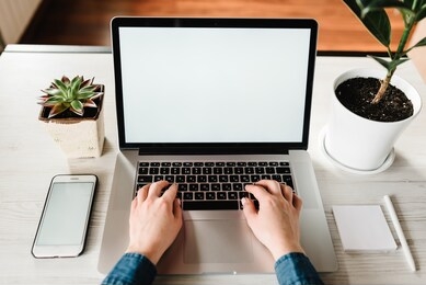 mockup image blank screen laptop computer, cell phone with white background for advertising text. hands woman using laptop on table. writing, typing. freelance concept. work home. marketing, design.