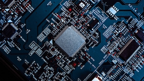 macro close-up shot of microchip, cpu processor on black printed circuit board, computer motherboard with components inside of electronic device, part of supercomputer.