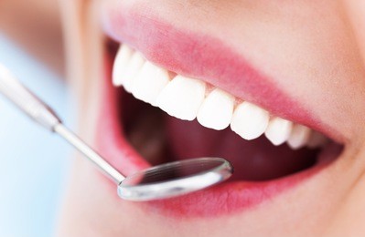 woman teeth and a dentist mouth mirror 
