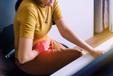 female suffering from abdominal pain,period cramps,hands squeezing belly,stomach pain,woman having painful stomach ache during working at home