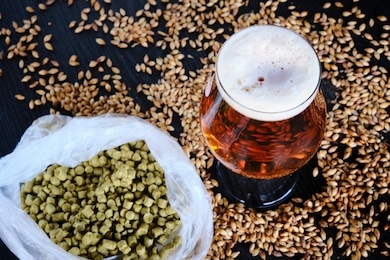 view of the components to make a frozen red or amber craft beer and the glass beer coup over a black wooden table
