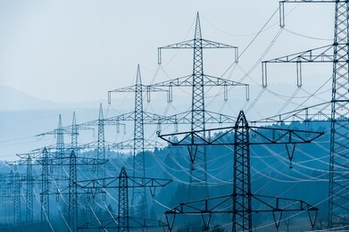 high tension cables with forested hills behind