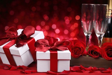 champagne,gift box and rose on red background