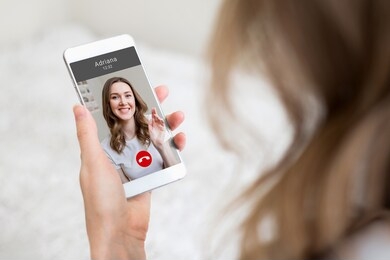 a young girl holds a mobile phone in hand and talking to her girlfriend on video chat, video calls, conference
