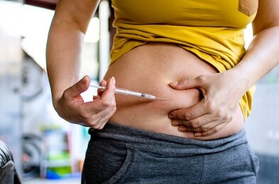 woman making hormonal therapy injection into her belly. close up syringe pen. person in vitro fertilisation treatment injecting hormone for pregnancy.