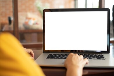 women using laptop computer working at home with blank white desktop screen.