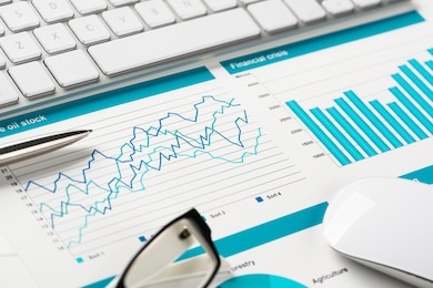business workplace with keyboard mouse and papers with graphs and diagrams