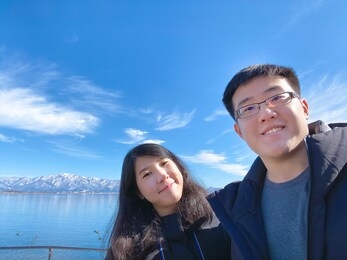traveler asian couple looking at camera while standing outdoors.
make selfie photo on travel.
happy and loves emotions concept.
