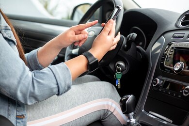 woman driver using a mobile, smartphone during driving her car, dangerous concept