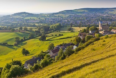 idyllic rural view of gently rolling patchwork farmland and villages with pretty wooded boundaries, in the beautiful surroundings of the cotswolds, england, uk.