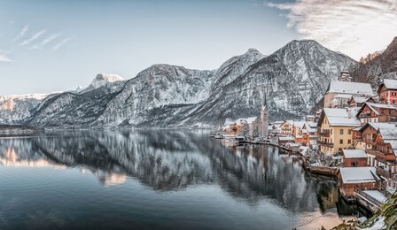 panorama view of snowy village hallstatt by lake at foot of snow mountain with clear sky in winter in austria