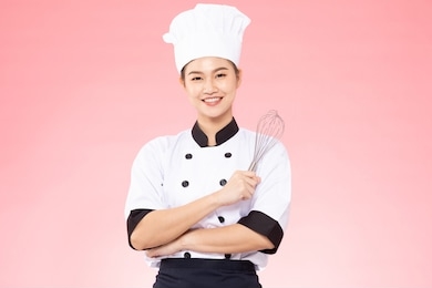 beautiful asian chef woman smile and holding stainless balloon whisk isolated on pink background,happiness and cheerful professional chef concept