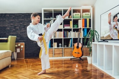 taekwondo boy exercising at home in living room.