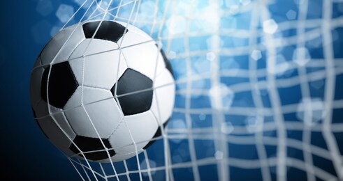 soccer ball in goal on blue background