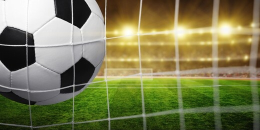 soccer ball in the net, success goal concept on stadium light background.