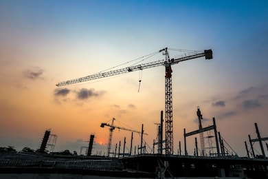 new construction site with crane and mechanical equipments on sunset background.