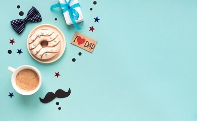 happy fathers day flat lay on blue, copy space. morning coffee, donut, gift box with confetti and moustache, father's day celebration concept.