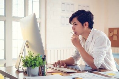 young asian man designer planning develop application develop for mobile phone at home.