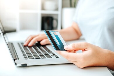 asian young woman resting and browsing internet with laptop holding credit card online shopping concept