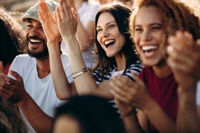group of fans watching a sports event in the stands of a stadium. group of men and women spectators cheering for their team victory.