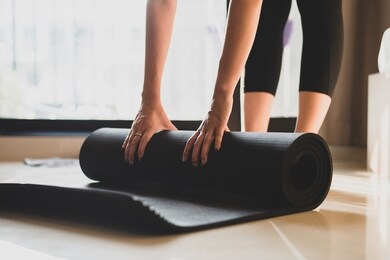 woman practicing yoga and meditating indoors. beautiful girl preparing material for practice class. calmness and relaxation. female happiness and yoga concept.