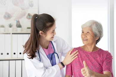 asian female doctor examine elderly female patient in hospital, they feeling happy and smiling, patient show thump up sign, elderly healthcare promotion concept