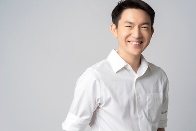 studio portrait of an attractive young asian businessman white shirt half body isolated on grey background