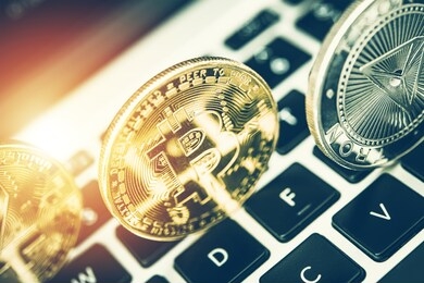 view of transparent silver and golden crypto currency on top of computer keyboard. 
