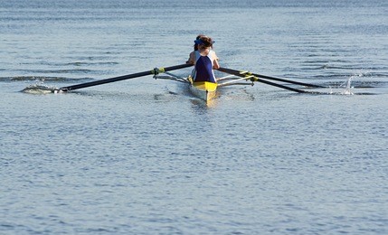 rowing team working in unison to compete in a regatta by racing specially built row boats