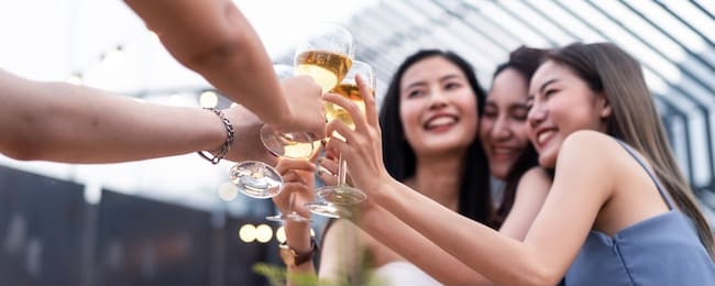 group of young cute asian girl gang best friends having party at rooftop restaurant. girls drinking beer alcohol and toasting glass feeling happy enjoy, fun with smile face. night lifestyle concept.
