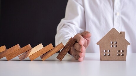 insurance with hands protect a house. home insurance or house insurance concept