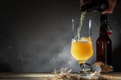 glass of homemade beer on a wooden table. glass of craft beer on a dark background.