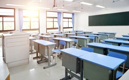 empty classroom with blue desks and chairs.
