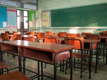 emphasize primary level blur with no students, no children or teachers with chairs and desks only.