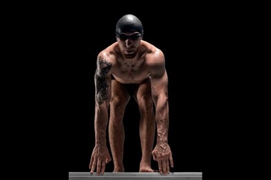 portrait of a swimmer who is preparing for a jump. the concept of swimming and water games. front view. mixed media