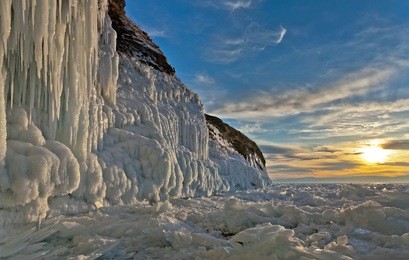 baikal  lake in winter. ice and icicles on a rocky island at sunset