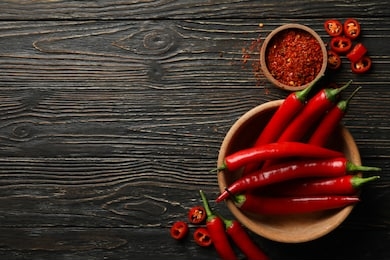 spices and bowl with chilli pepper on wooden background
